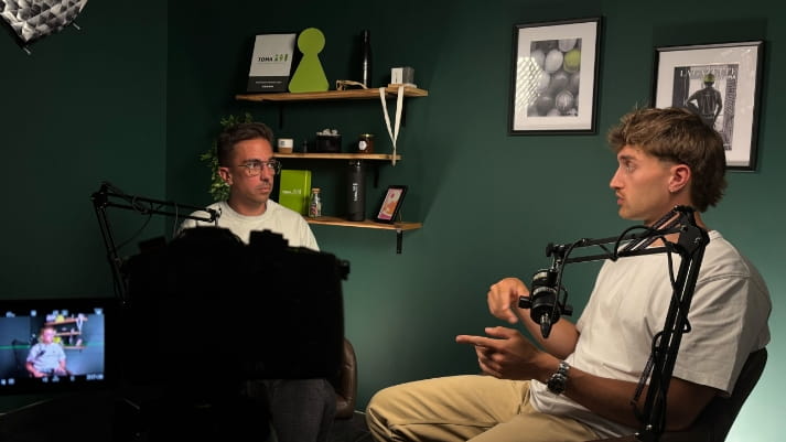 Enregistrement d'un podcast face à face dans le studio TOMA, micros sur bras articulés et mur vert